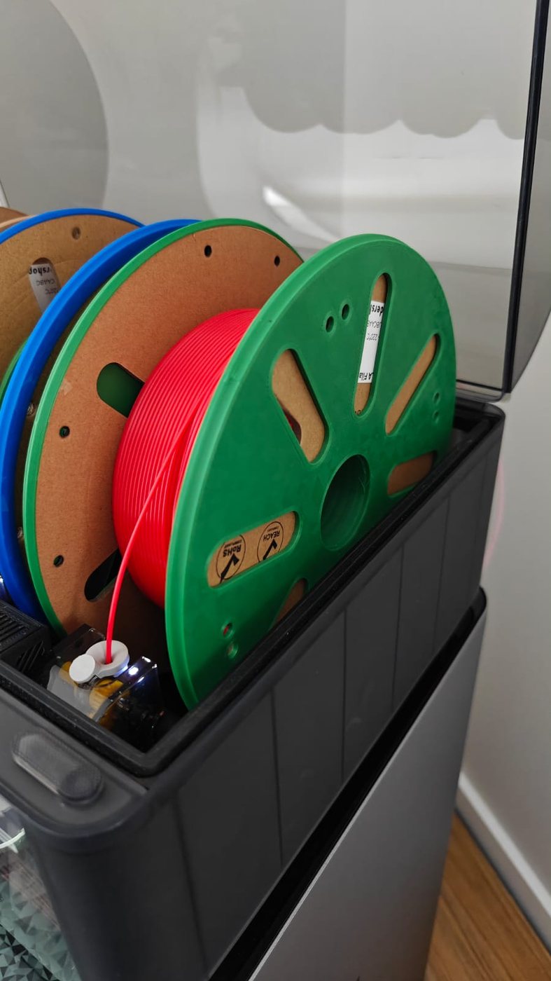 Cardboard filament spool reinforced with printed rings and running inside an AMS.