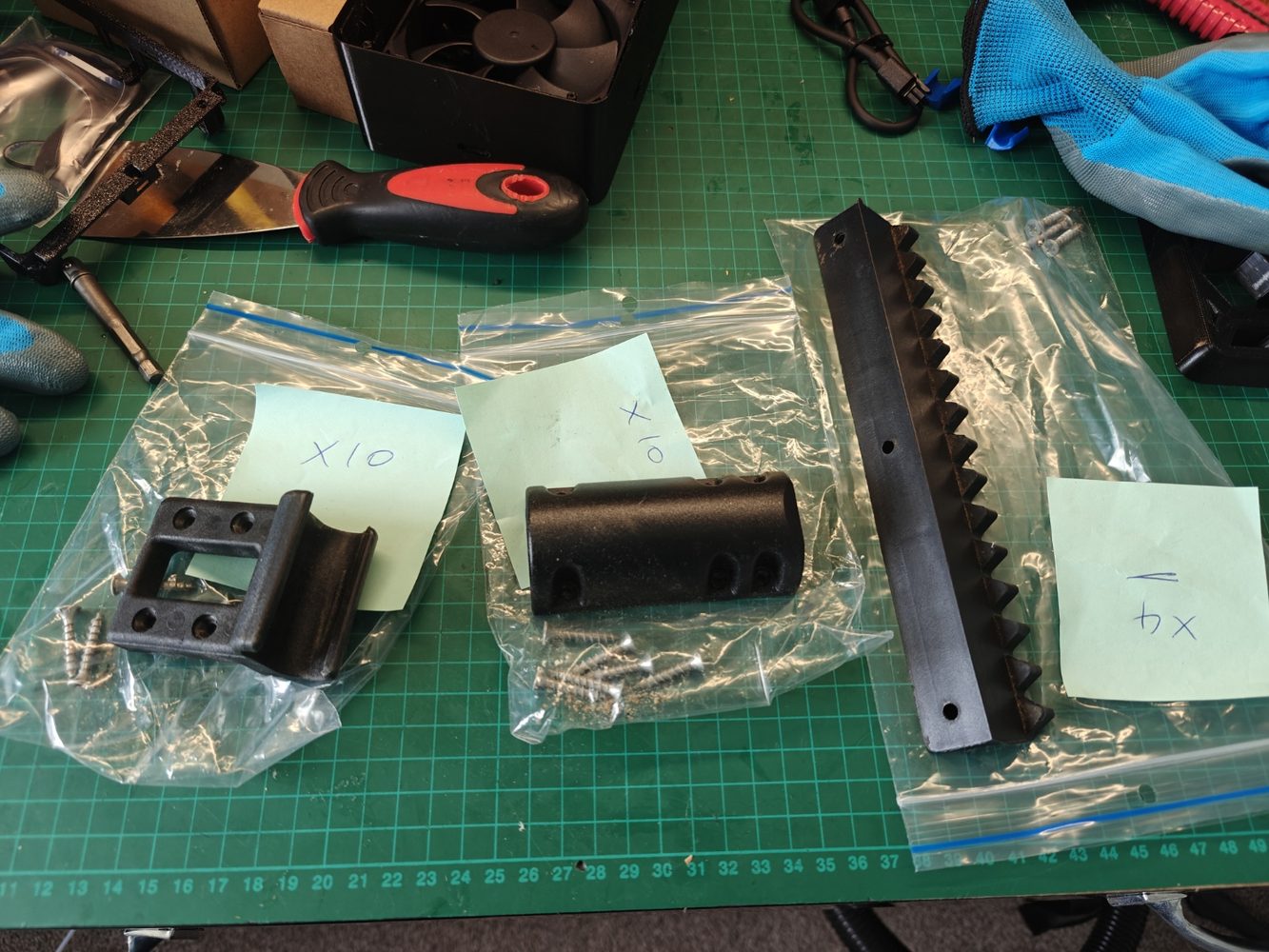 Batch of black 3D printed functional parts packed for delivery.