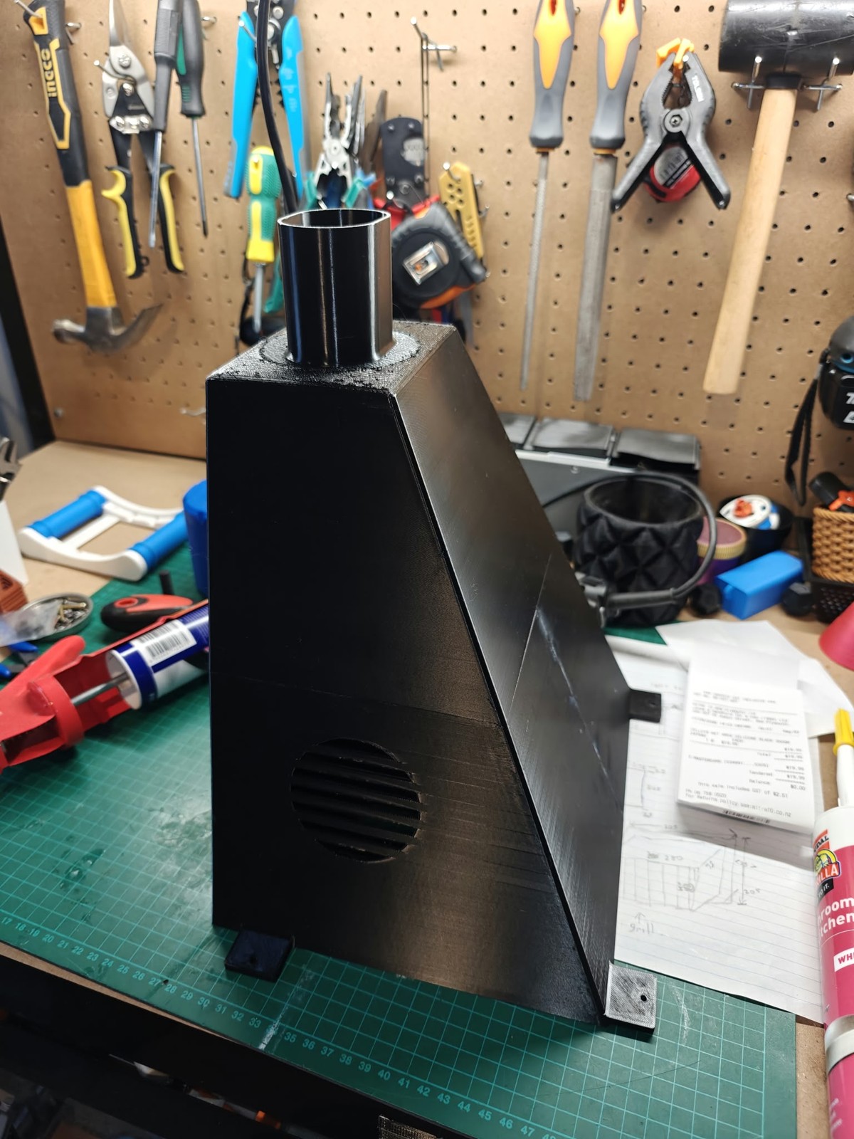 Assembled black gutter funnel on the workshop bench, with joined sections, a round outlet and mounting tabs.