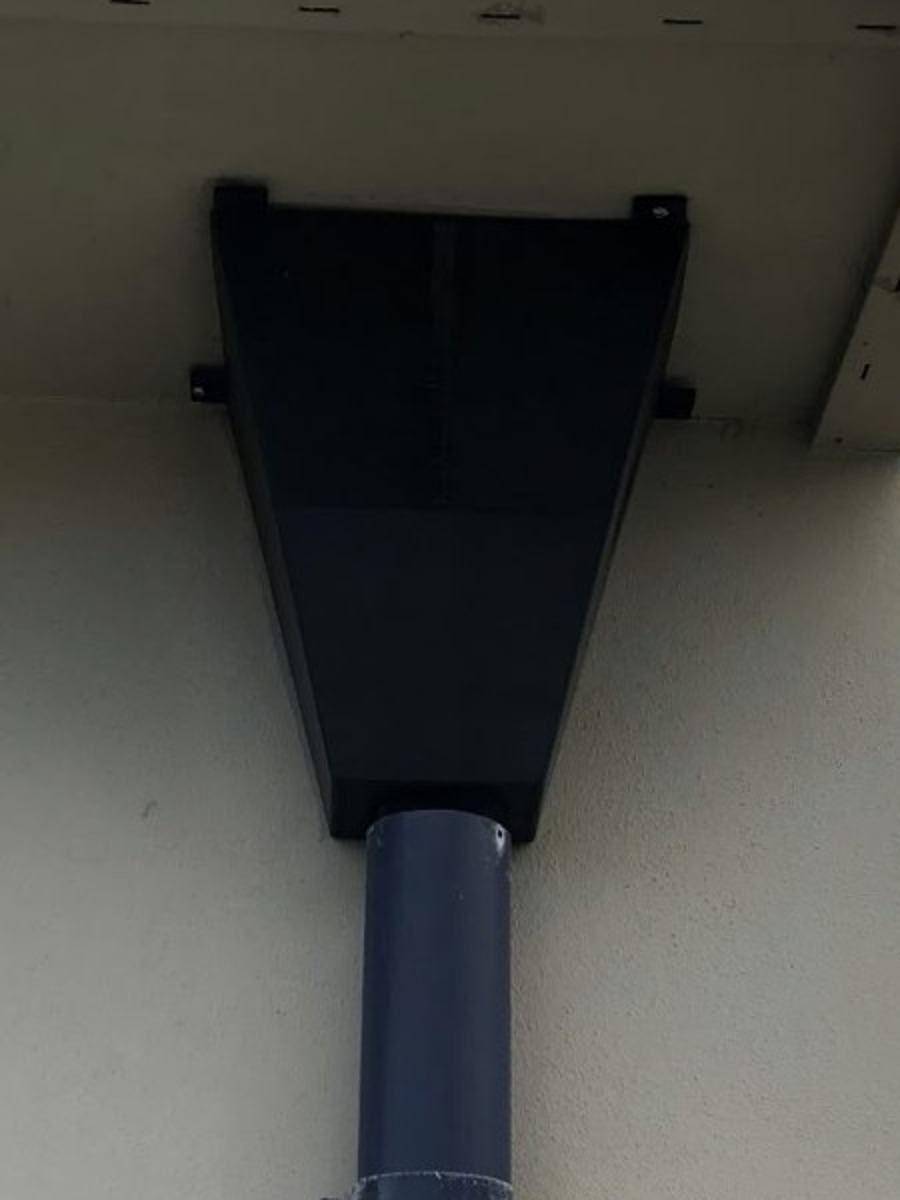 Black printed gutter funnel installed beneath the eaves and connected to the downpipe at the Dolans’ home.