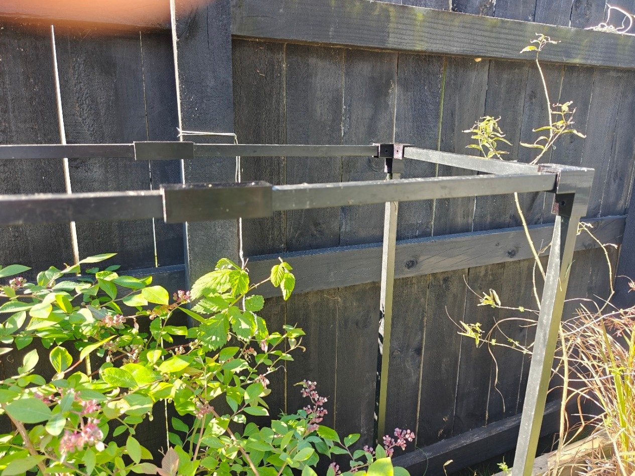Top rails of the frame joined with printed sleeves and corner connectors along a fence.
