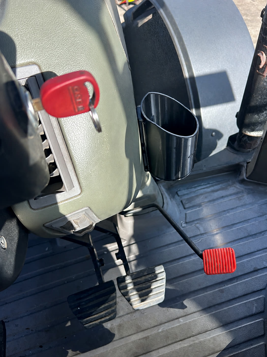 Black Quality3Ds bottle holder mounted beside a tractor seat, shown empty.