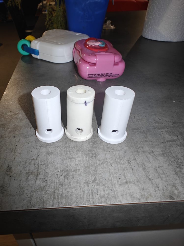 Original white toy part beside two 3D printed replacement parts.