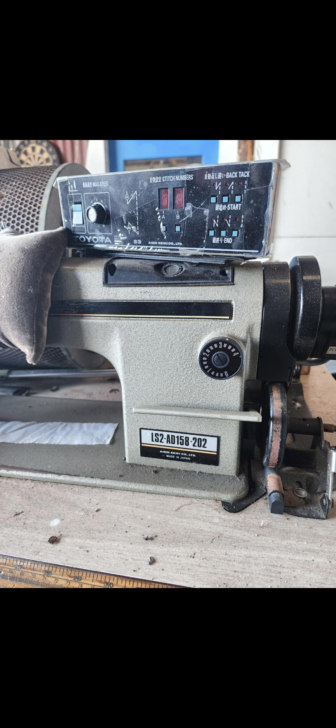 Toyota industrial sewing machine with the control panel mounted above the machine body.