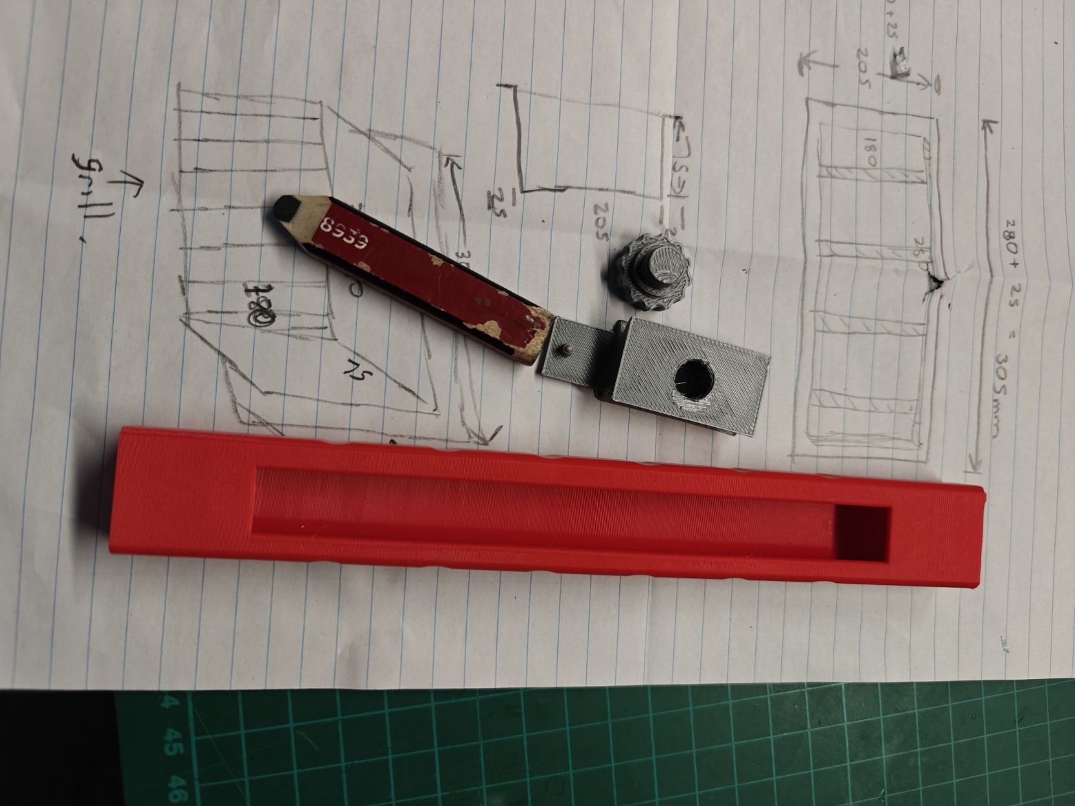 Red pencil holder body, grey clamp, thumb screw and short pencil shown separately.