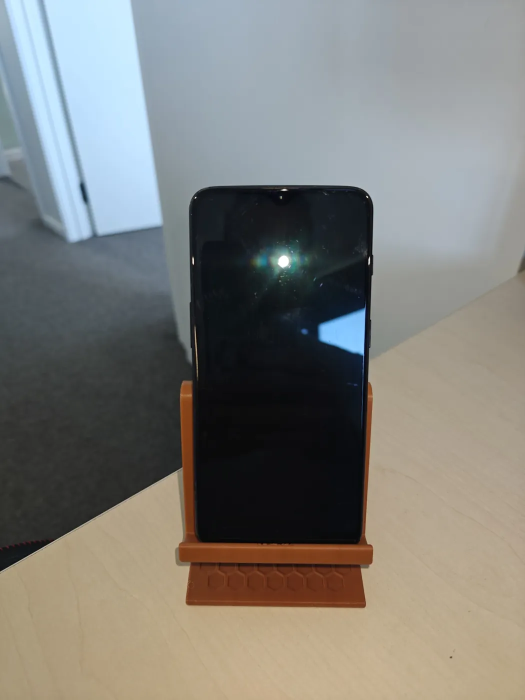 Front view of a phone standing upright in the Q3D phone stand.