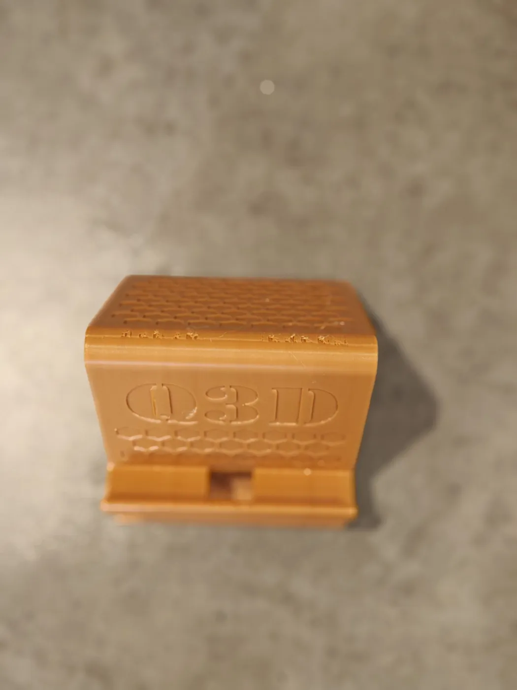 Top-down view of the Q3D phone stand showing the cable slot in the front ledge.